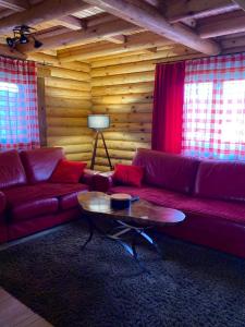 a living room with a red couch and a table at LogCabin Žabljak in Žabljak