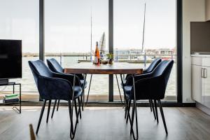 里布尼茨达姆加滕Hausboot Küstennebel 2的一张餐桌，几把椅子，还有一扇大窗户