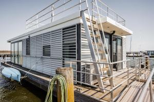里布尼茨达姆加滕Hausboot Küstennebel 2的水面上的小房子