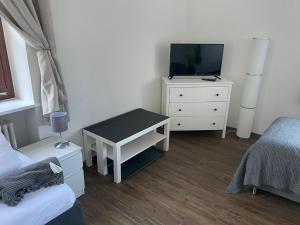 een slaapkamer met een bed en een tv op een dressoir bij Charmante Wohnung am Neckar in Bad Wimpfen