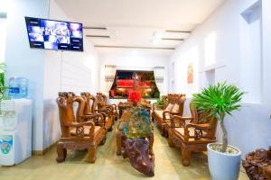 a living room with a table and chairs and a tv at Yangsinghotel in Buôn Kô Sir