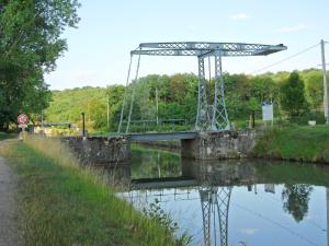 eine Brücke über einen Fluss mit seiner Reflexion im Wasser in der Unterkunft Canal du Nivernais Gîtes Le champ radis in Marigny-sur-Yonne