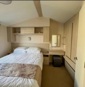 a bedroom with two beds and a desk and a mirror at The Ruby Lido Beach Prestatyn in Prestatyn
