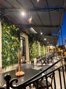 an outdoor patio with tables and chairs and plants at Hotel Restaurant Christophe Colomb in Calvi
