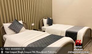 a hotel room with two beds in a room at Hotel Akbar International in Rawalpindi