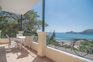 een balkon met een tafel en stoelen en uitzicht op het water bij Villa Theodora View Apartments Eleni in Agios Georgios Pagon
