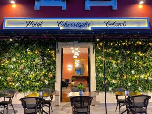un restaurante con mesas y sillas frente a un edificio en Hotel Restaurant Christophe Colomb, en Calvi