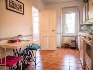 cocina con mesa, sillas y puerta en Gîtes du Hameau Baylesse en Saint-Jean-dʼAigues-Vives