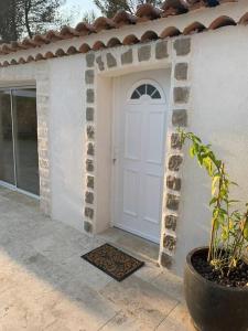 a white door of a house with a potted plant at Jolie maison avec vue sur piscine in Bouc-Bel-Air
