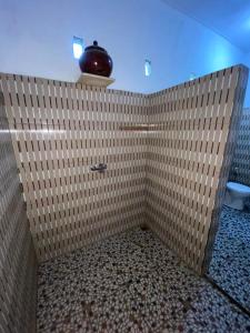 a bathroom with a shower with a tiled wall at Murni house in Amed