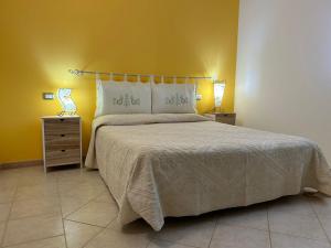sypialnia z dużym łóżkiem i żółtą ścianą w obiekcie Casa sulla collina - Sant'Antioco w mieście SantʼAntìoco