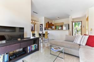 sala de estar con sofá y TV en 3 bedroom Villa Athina with private pool and golf views, Aphrodite Hills Resort en Kouklia