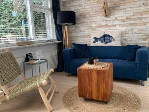 a living room with a blue couch and a table at Appartement 't Zomerhuis in Zandvoort