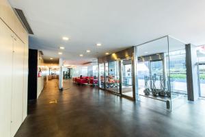 a room with glass walls and a lobby with chairs at ibis Montevideo Rambla in Montevideo