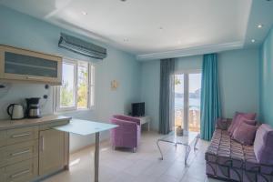 een woonkamer met een bank en een tafel bij Villa Theodora View Apartments Eleni in Agios Georgios Pagon