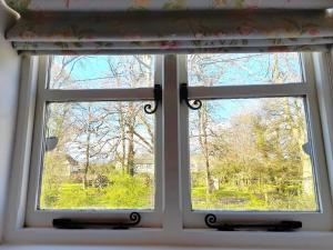 una ventana con vistas a un patio en Cotswold Cottage Bed & Breakfast en Luckington