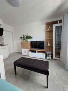 a living room with a bench in front of a tv at Apartment Mara in Dubrovnik