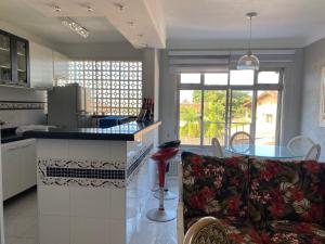 a kitchen with a couch and a table in a room at Apartamento enseada Guarujá in Guarujá +13 photos