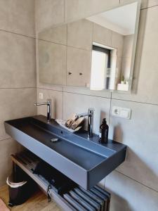 a bathroom with a black sink and a mirror at Ferienhaus am Lanzer See in Lanze +6 photos
