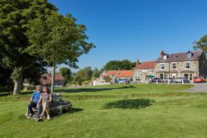 a man and a woman sitting on a park bench at F&H Camping in Danby