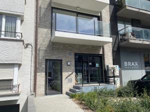 a brick building with a balcony and a glass door at Monico 0202 ref 49 in Koksijde