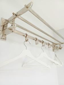 a metal coat rack with a white shirt on it at 'The Limes' - Air-Con Two Double Bedroom Holiday House with Private Garden in Kent