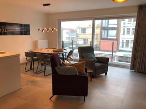 a living room with a table and chairs and a kitchen at Monico 0202 ref 49 in Koksijde