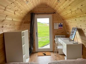 Habitación con escritorio y ventana en una cabaña en F&H Camping, en Danby