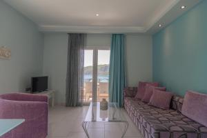 een woonkamer met een bank en een tv bij Villa Theodora View Apartments Eleni in Agios Georgios Pagon