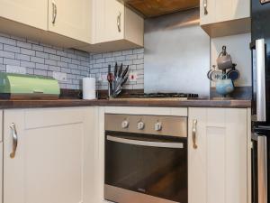 een keuken met witte kasten en een fornuis bij Bridgefield House in Ashford