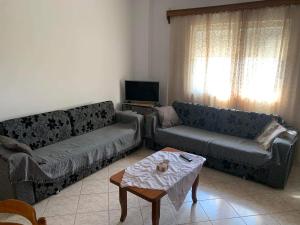 a living room with two couches and a table at Nardi Guesthouse in Ksamil