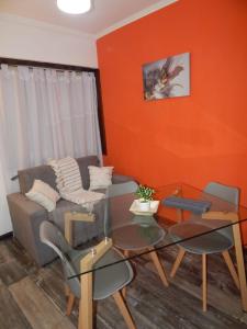 uma sala de estar com um sofá e uma mesa de vidro em Corrientes em Mar del Plata