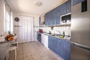 una pequeña cocina con armarios azules y fregadero en El Olivar Beach Golf, en Caleta de Fuste