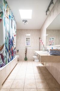 Un baño con dos lavabos y un gran mural en la pared. en El Olivar Beach Golf, en Caleta de Fuste