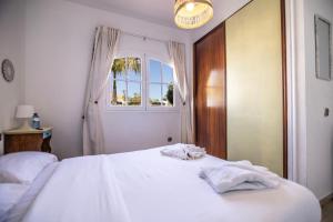 Un dormitorio con dos camas blancas y una ventana. en El Olivar Beach Golf, en Caleta de Fuste 17 fotos más