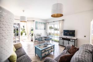sala de estar con sofá, TV y mesa en El Olivar Beach Golf, en Caleta de Fuste