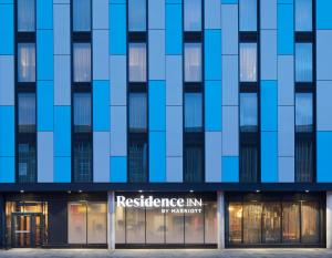 un edificio alto azul con un restaurante frente a él en Residence Inn by Marriott Slough, en Slough