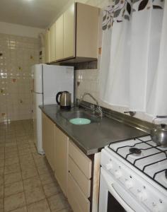 uma cozinha com um fogão e um frigorífico branco em Corrientes em Mar del Plata