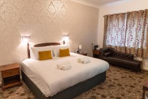 a hotel room with a large bed and a chair at Hamlet Hotels Maidstone in Maidstone