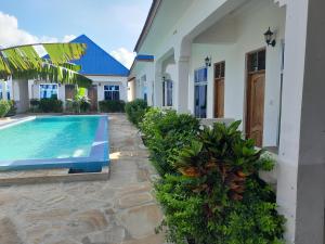a house with a swimming pool next to a house at Serenity 2 - Jambiani in Jambiani