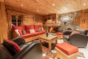 a living room with a red couch and a stone fireplace at La Ferme du Var in La Clusaz