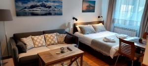 a living room with a bed and a couch at Brzeće Center Studio Mitrovski Gondola 300m in Kopaonik