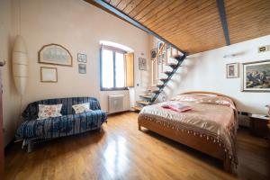 a bedroom with a bed and a couch and a staircase at L'Olea casa vacanze in Campobasso
