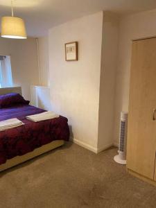 ein kleines Schlafzimmer mit einem Bett und einer Tür in der Unterkunft Julia’s flat in Maryport