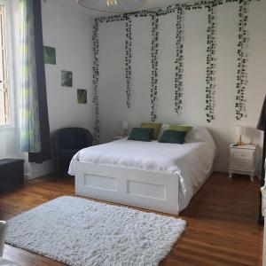 ein Schlafzimmer mit einem weißen Bett und einem weißen Teppich in der Unterkunft VILLA DE SOUZA in Bouillé-Loretz