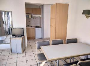 Habitación con mesa, sillas y cocina. en Centre Juan Les Pins, en Juan-les-Pins