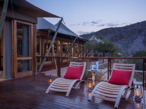 two chairs with red pillows sitting on a deck at Sanbona Wildlife Reserve in Barrydale