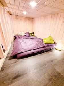 ein großes Bett in einem Zimmer mit Holzwänden in der Unterkunft Holiday cabin BUUDA in Salacgrīva