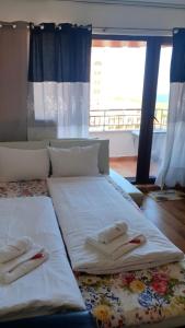 a large bed with two towels on top of it at Студио Уют Марина Кейп in Aheloy