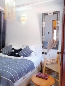 een slaapkamer met een bed, een spiegel en een tafel bij Enjoy Sunsets at this Lovely & Romantic Gest House in Marrakesh